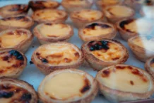 Tarte de nata caseira tradicional: Segredos revelados Close-up of delicious Portuguese custard tarts, perfect for dessert lovers.