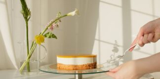 Elegant lemon cheesecake on a stand surrounded by natural flowers. Perfect for celebrations or culinary projects.
