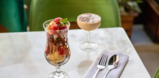 A delicious ice cream sundae with strawberries and a creamy dessert on a white table.