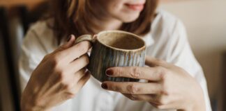 Enjoy a relaxing moment with a warm cup of coffee in a handmade mug, perfect for cozy mornings.