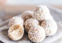 Receita de Bolo de Coco rápido com leite condensado irresistível A close-up of coconut bliss balls on a linen cloth, showcasing their texture and sweet appeal.