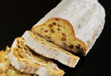 Receita de Bolo Rainha caseiro com frutos secos para encantar Sliced traditional German Stollen dusted with powdered sugar, perfect for dessert or breakfast.