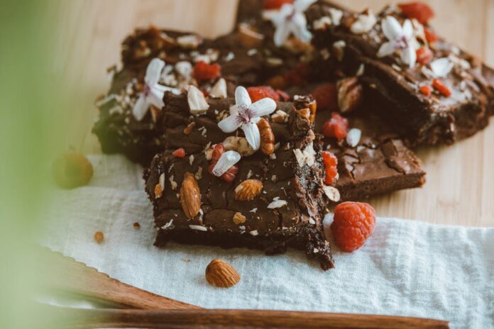 Receita de Brownies de Chocolate Úmidos e Fáceis: Surpreenda! Close-up of chocolate brownies adorned with almonds, raspberries, and white flowers on a wooden board.