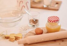 A cozy setup with baking ingredients for holiday cookies, featuring a rolling pin, egg, and decorations.