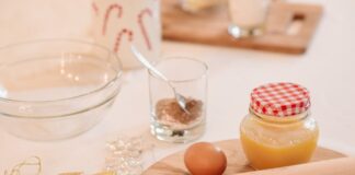 A cozy setup with baking ingredients for holiday cookies, featuring a rolling pin, egg, and decorations.