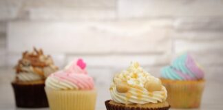 Deliciously decorated cupcakes with colorful frosting displayed on a wooden surface, perfect for dessert lovers.