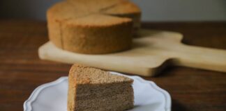 A slice of moist sponge cake on a white plate, perfect for dessert indulgence.