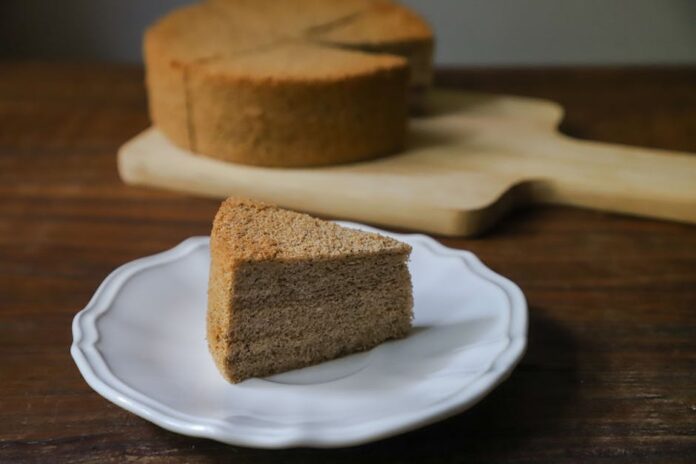 Bolo Caseiro Sem Batedeira: Receita Surpreendente e Fácil! A slice of moist sponge cake on a white plate, perfect for dessert indulgence.