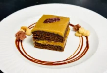 Bolo de Caramelo Delicious chocolate cake drizzled with caramel sauce and garnished elegantly on white plate.