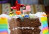 Vibrant rainbow cake with a Malaysian flag, perfect for celebrations and parties.