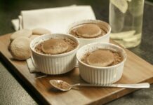 Bolo de Iogurte natural fofinho: O segredo para a perfeição Indulge in homemade tiramisu served in white ramekins on a wooden board. A perfect dessert choice.