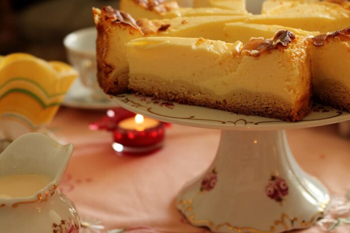 Bolo fácil com poucos ingredientes: descubra a receita simples! A rustic cheesecake slice on a floral plate with a cozy ambiance.