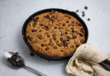 Bolo feito na frigideira simples: Descubra o segredo delicioso Delicious homemade skillet cookie with chocolate chips and pecans, perfect for dessert indulgence.