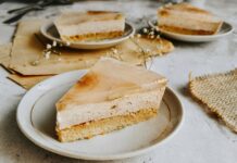 Receita de Bolo de Banana simples e económico que encanta Enjoy a delicious slice of rustic banana cream cake with a delicate floral touch, perfect for dessert lovers.