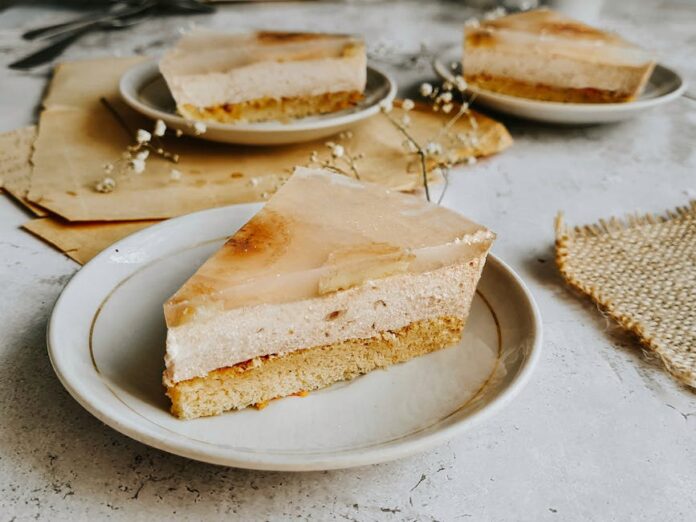 Receita de Bolo de Banana Simples e Econômico que Encanta! Enjoy a delicious slice of rustic banana cream cake with a delicate floral touch, perfect for dessert lovers.