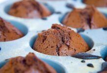 Receita de Bolo de Chocolate fácil: Sem batedeira e delicioso Delicious homemade chocolate cupcakes fresh out of the oven in a baking tray.