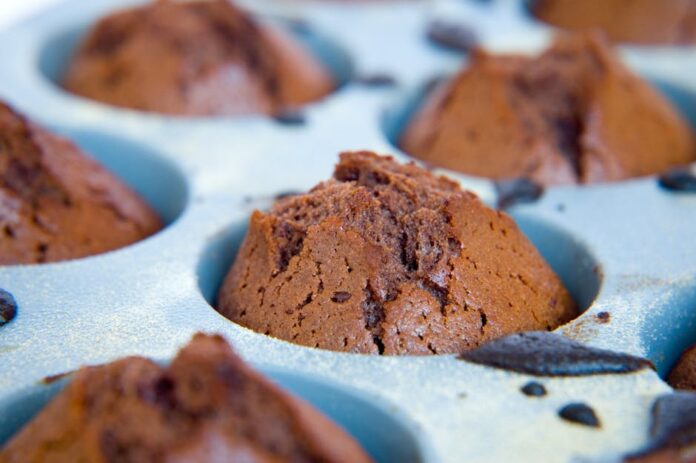 Receita de Bolo de Chocolate Fácil: Sem Batedeira e Delicioso! Delicious homemade chocolate cupcakes fresh out of the oven in a baking tray.