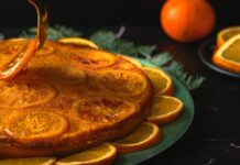 Receita de Bolo de Laranja econômico: Sabor que surpreende A beautifully decorated orange cake with candied orange slices, perfect for dessert lovers.