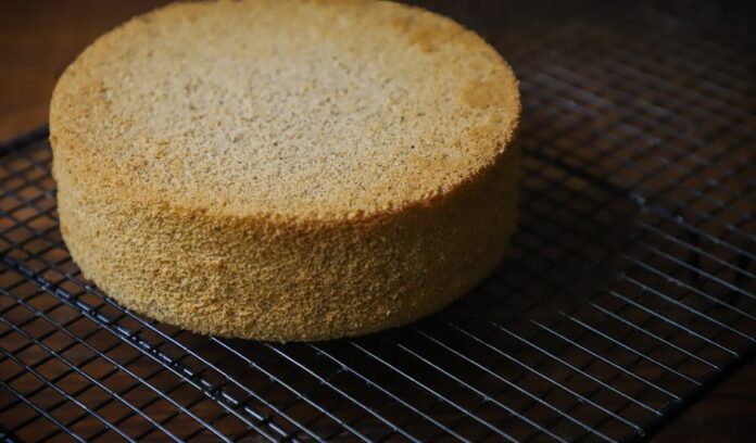 Receita de Bolo Fofo para Levar ao Trabalho: Surpreenda-se! Freshly baked sponge cake resting on a wire cooling rack, perfect for desserts.