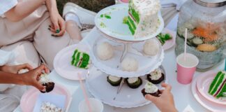 Adults and children enjoying a festive garden party with vibrant cakes and cupcakes.