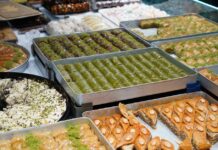 Baklava: Descubra o segredo do doce turco perfeito An array of freshly baked Turkish desserts including baklava and lokum, showcasing a delicious variety.