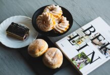 Bola de Berlim: Descubra o segredo A selection of German sweets and pastries with a Berlin magazine, perfect for a cozy breakfast.