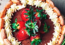 Charlotte Russe: Um doce clássico com um sabor marcante Top view of a chocolate cake garnished with fresh strawberries and whipped cream, creating a delightful dessert.