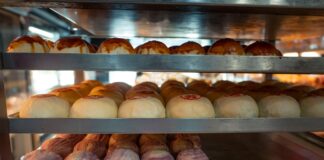 Assorted traditional Asian buns and pastries displayed on bakery shelves, inviting and fresh.