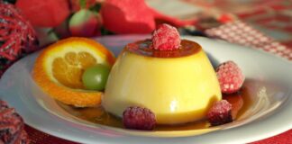 Indulge in creamy flan topped with raspberries, paired with citrus and caramel sauce for a delightful dessert treat.