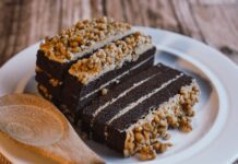 Bolo de Aveia húmido caseiro Indulgent chocolate cake with nut topping, perfect for dessert lovers.