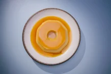 Flan Perfeito: A sobremesa que derrete na boca A delicious Brazilian flan on a white plate, perfect for food photography and culinary websites.