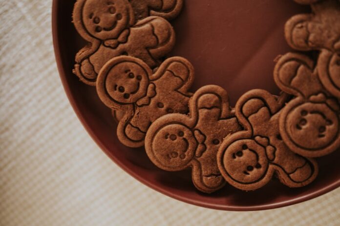 Descubra o Segredo do Sabor Autêntico do Lebkuchen! A close-up view of gingerbread men cookies arranged on a brown plate creating a festive atmosphere.