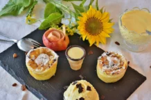 Strudel de Maçã: Descubra o segredo A cozy setup featuring apple strudel with vanilla sauce, ice cream, and a sunflower for a touch of brightness.