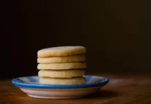Shortbread: Segredos de um sabor único A stack of golden butter cookies on a ceramic plate, perfect for dessert inspiration.