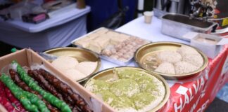 A variety of Middle Eastern desserts displayed at a street food market, featuring vibrant colors and textures.