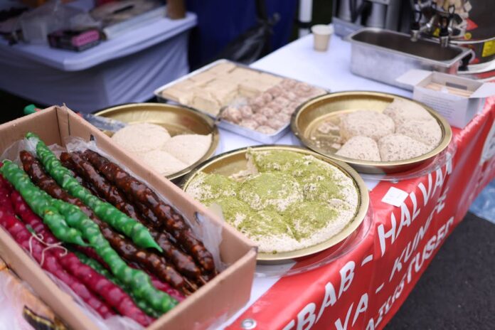 Descubra os Segredos da Halva: Doce Tradição Milenar A variety of Middle Eastern desserts displayed at a street food market, featuring vibrant colors and textures.