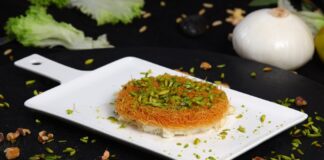 Close-up of mouthwatering Arabic Kunafa topped with chopped pistachios.