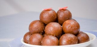 Close-up of a traditional Indian dessert, Gulab Jamun, served on a white plate.
