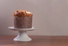High-quality image of a traditional Italian panettone on a white cake stand.