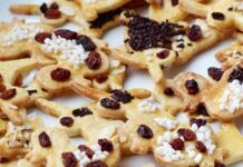 Doce caseiro para festas simples: Ideias rápidas e criativas Delicious homemade gingerbread cookies decorated with raisins and sprinkles. Perfect for festive occasions.