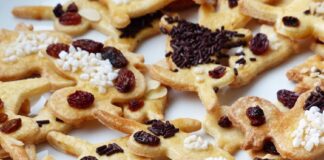 Delicious homemade gingerbread cookies decorated with raisins and sprinkles. Perfect for festive occasions.
