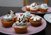 Doces fáceis para vender em casa: 5 receitas surpreendentes Close-up of assorted chocolate cupcakes with decorative creamy toppings on pastel plates.