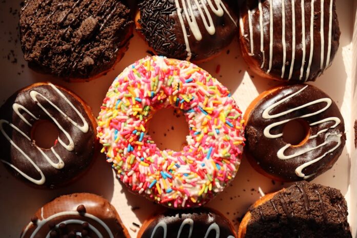Donuts irresistíveis: Descubra os sabores mais inusitados! Bright and delicious donuts with sprinkles and chocolate, perfect for bakery promotions and dessert lovers.