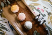 A vibrant assortment of mochi desserts elegantly presented on a wooden tray, perfect for food photography and culinary visuals.