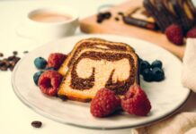 Close-up of a marble cake with raspberries and blueberries, perfect dessert setting.