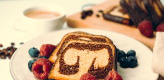 Close-up of a marble cake with raspberries and blueberries, perfect dessert setting.