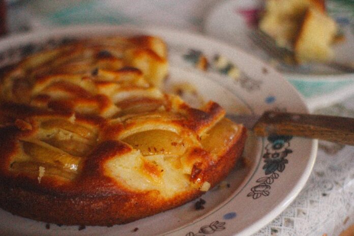Receita de Apple Pie: O Segredo para a Tarte Perfeita! Close-up of a rustic homemade apple pie on a vintage patterned plate, evoking a warm, cozy mood.