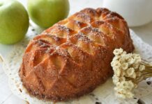 Delicious homemade apple cake dusted with sugar, paired with fresh green apples and decorative flowers.