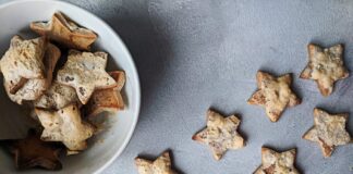 Flat lay of star-shaped homemade cookies in a bowl, perfect for Christmas treats.