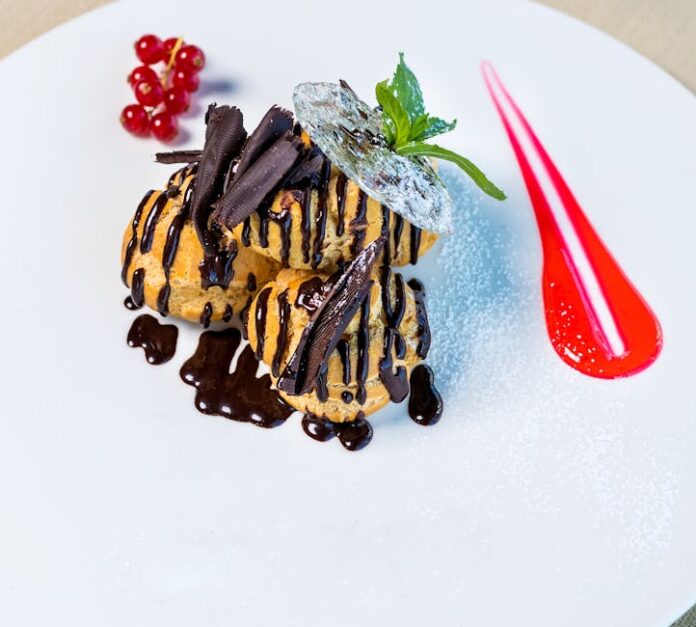 Receita de Profiteroles: Surpreenda com Essa Delícia! Sumptuous profiteroles topped with chocolate sauce and berries, presented on a white dish.